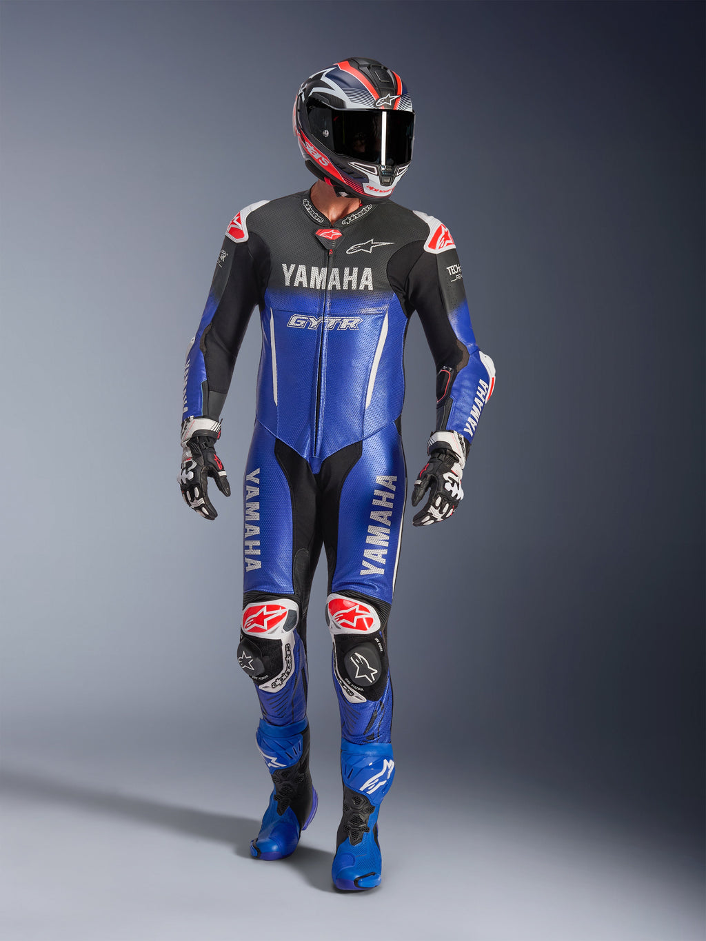Yamaha GP-R7 læderdragt i ét stykke, motorcykelracerdragt, metallisk blå og sort med røde og hvide detaljer, med Yamaha- og GYTR-branding, vist med matchende hjelm, racerhandsker og blå støvler, professionelt racerudstyr