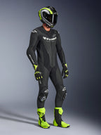 Alpinestars GP Force V2 læderdragt, 1-piece motorcykeldragt, sort med hvid branding, båret med matchende neongul og sort hjelm, handsker og støvler, højtydende racingudstyr til bane- og sportskørsel