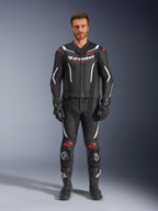 Alpinestars GP Force V2 2-Piece Leather Suit, Motorcycle Racing Suit, Black White and Red Fluo, worn by a model with matching black gloves and boots, featuring perforated leather panels, white and red fluo accents, and a sleek aerodynamic design for track and sport riding