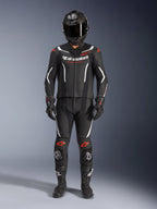Alpinestars GP Force V2 Leather Suit 2-Piece, Motorcycle Racing Suit, Black White and Red Fluo, featuring white Alpinestars logo on chest and red accents on shoulders and knees, worn with black full-face helmet, black gloves, and black boots for a complete performance gear set