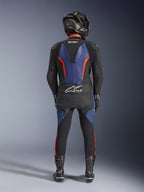 Alpinestars GP Force V2 Leather Suit 2-Piece, Black Blue Red Fluo, full rear view of a rider in complete racing gear, featuring blue leather panels on the back and legs with fluorescent red accents, Tech-Air® Ready logo on the lower back, paired with a carbon fiber helmet, black gloves, and racing boots.