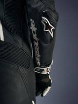 Alpinestars Stella GP-R7 1-Piece Leather Suit, Black, close-up of the arm featuring the DFS RR elbow slider with the Astars logo, white Alpinestars text on the forearm, and perforated leather zones