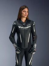 Alpinestars Stella GP-R7 Leather Suit, Women's 1-Piece Racing Suit, Black with white and grey accents, worn by a model, featuring perforated leather construction and Alpinestars branding on the chest, high-performance motorcycle gear