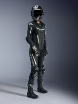Female rider wearing the Alpinestars Stella GP-R7 1-Piece Leather Suit in Black and White, featuring perforated leather and white logo accents, worn with a carbon-fiber racing helmet, black and white racing gloves, and black boots for a complete track-ready outfit.