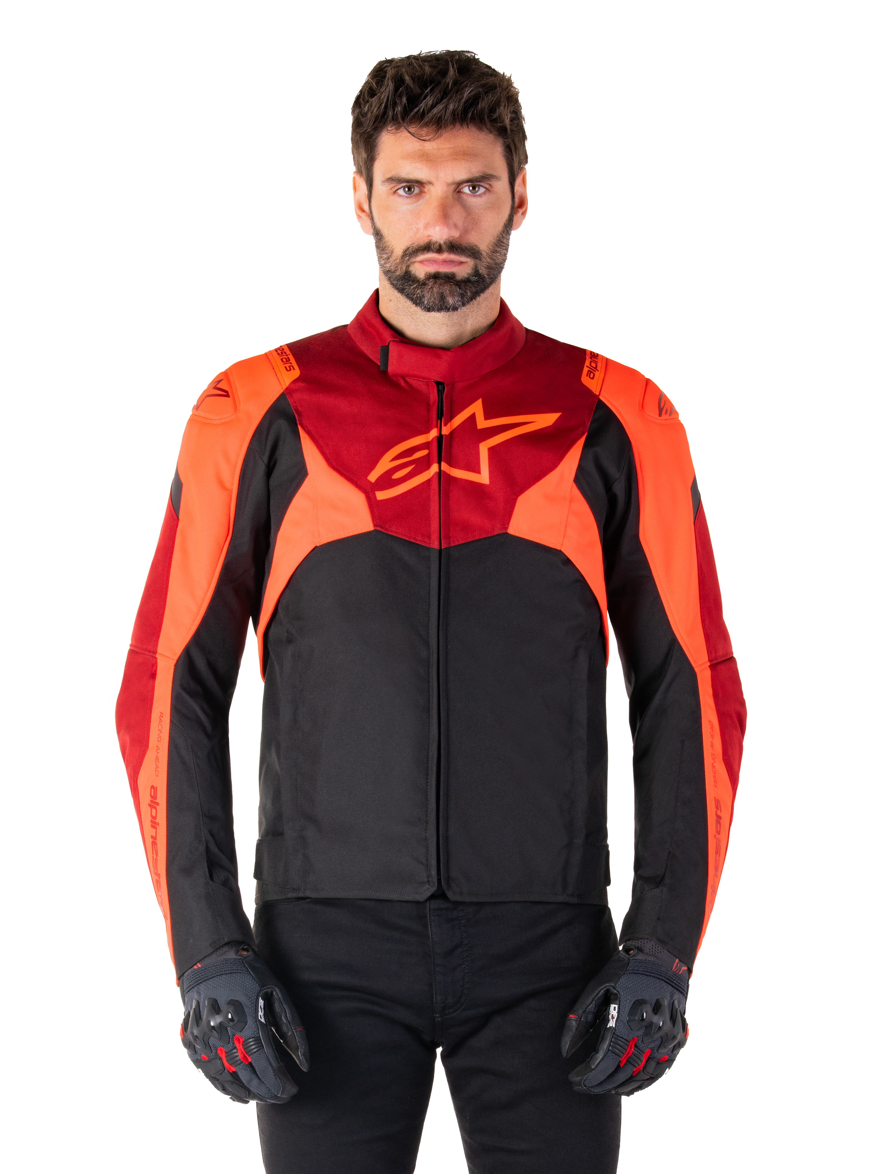 Alpinestars T-Jaws V4 Waterproof Jacket, sportstekstil motorcykeljakke, sort med rød fluo og mørkerøde detaljer, bæres af en mandlig model med matchende handsker, teknisk køreudstyr med fremtrædende stjernelogo på brystet.
