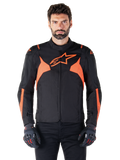 Alpinestars T-Jaws V4 Waterproof-jakke, sportslig motorcykeljakke, sort og rød fluo, med neondetaljer og et fremtrædende stjernelogo på brystet, båret af en mandlig model med sorte kørehandsker, strømlinet racer-inspireret tekstildesign