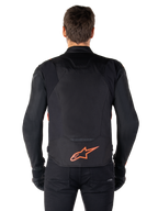 Alpinestars T-Jaws V4 vandtæt jakke, set bagfra, sort med rød fluo, med rødt Alpinestars-logo på lænden, teknisk tekstilkonstruktion, båret med sorte bukser og handsker for et komplet sportsligt kørelook