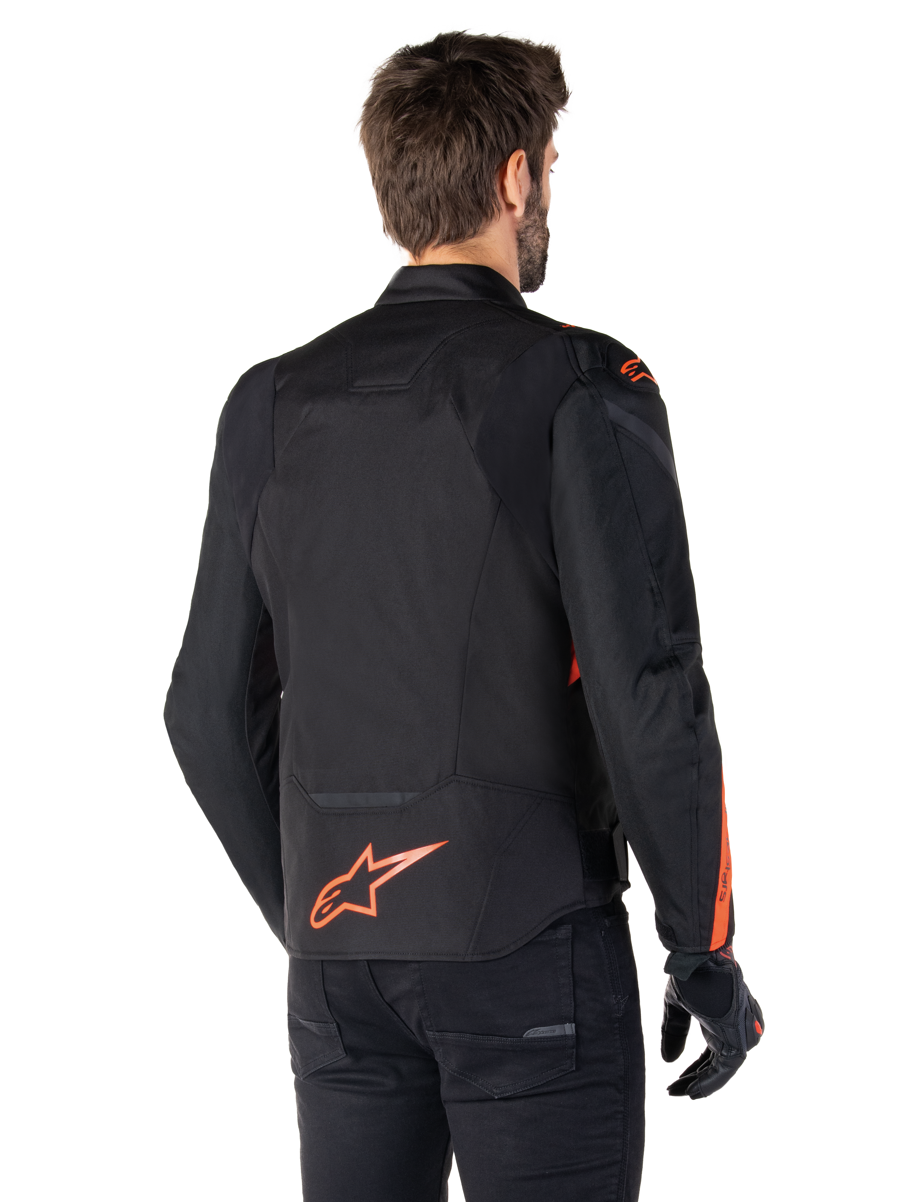 Mandlig model iført Alpinestars T-Jaws V4 Waterproof-jakke set bagfra, sort med røde fluo-detaljer, med et rødt fluo-logo nederst på ryggen og detaljer på skuldre og ærmer, sportsmotorcykeludstyr