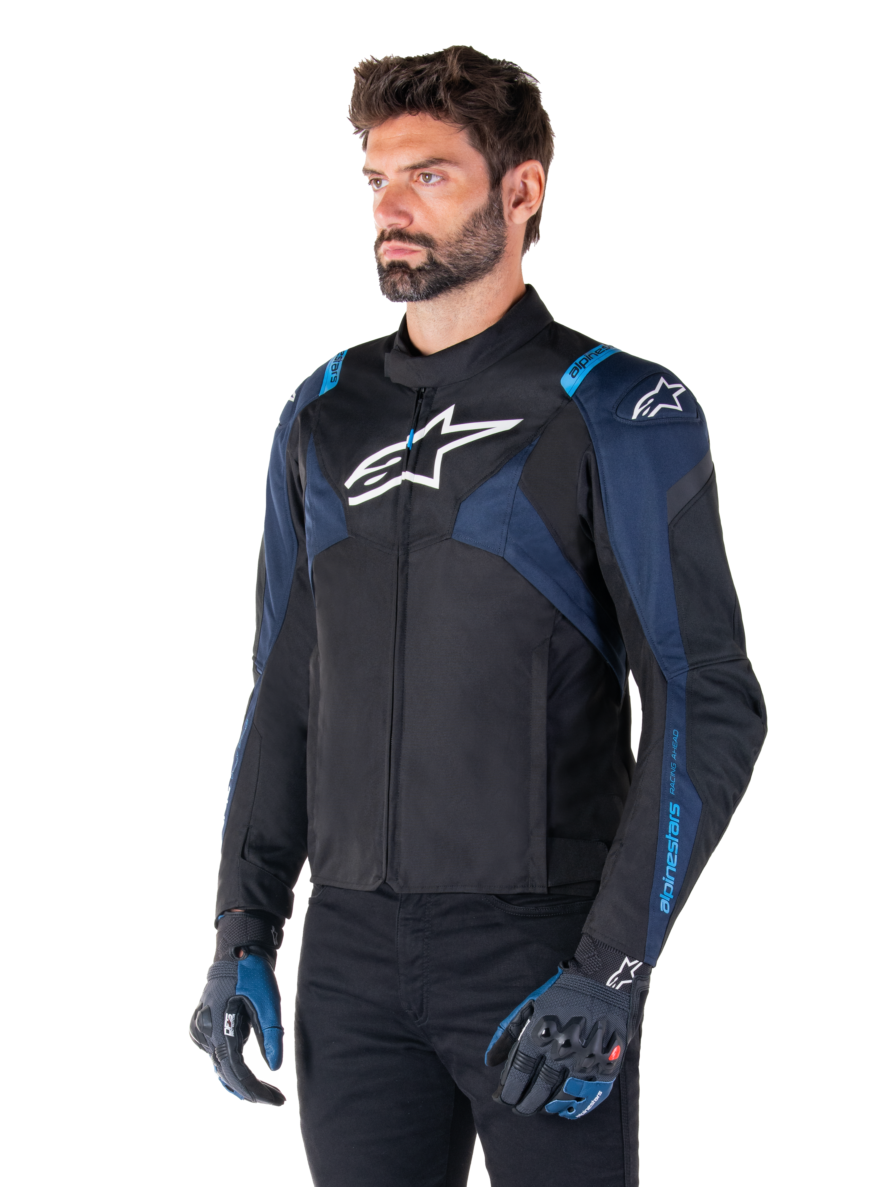 Alpinestars T-Jaws V4 Waterproof jakke, motorcykeljakke, sort, mørkeblå og Blithe Blue, båret af en model med matchende handsker og sorte bukser, med hvide Alpinestars-logoer på brystet og skuldrene og blå detaljer på ærmerne, sporty tekstil-køreudstyr