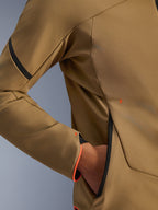 Close-up of Alpinestars Aeroshell Waterproof Jacket, Dark Khaki with black and orange fluo accents, detail of the hidden zipped hand pocket and sleeve cuff, stretch softshell textile for motorcycle riding