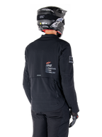 Alpinestars AMT-8 Stretch Drystar® XF jakke i sort, set bagfra på en motorcyklist, med 'AMT Alpinestars Motion Technology' branding på ryggen, teknisk ventilation med lynlås, kombineret med en sort motorcykelhjelm og handsker