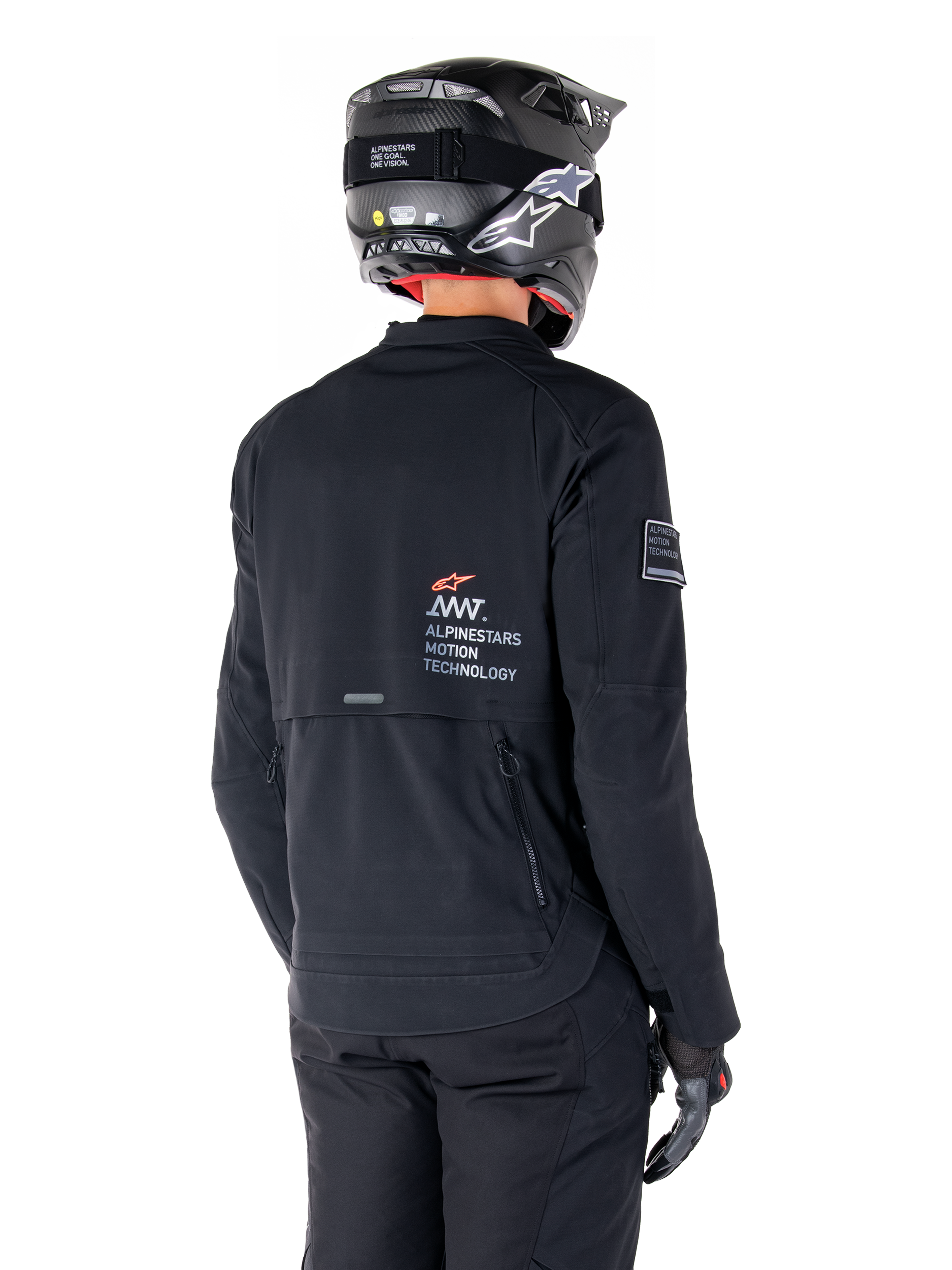 Alpinestars AMT-8 Stretch Drystar® XF jakke i sort, set bagfra på en motorcyklist, med 'AMT Alpinestars Motion Technology' branding på ryggen, teknisk ventilation med lynlås, kombineret med en sort motorcykelhjelm og handsker
