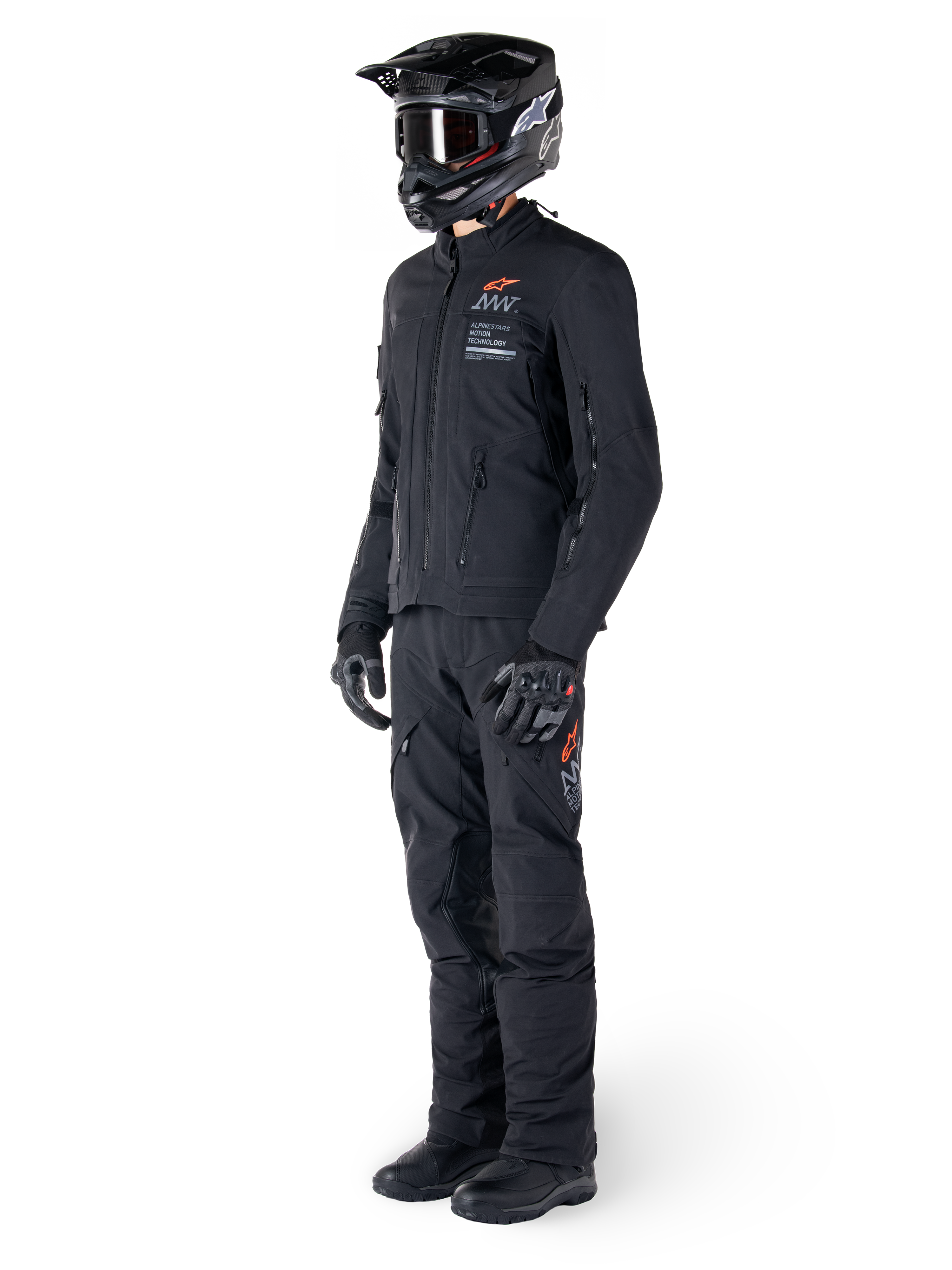 Alpinestars AMT-8 Stretch Drystar® XF-jakke, adventure-motorcykeljakke, sort, vist med matchende bukser, hjelm og handsker, med Alpinestars Motion Technology-branding og orange detaljer, slidstærk strækkonstruktion til adventure-kørsel