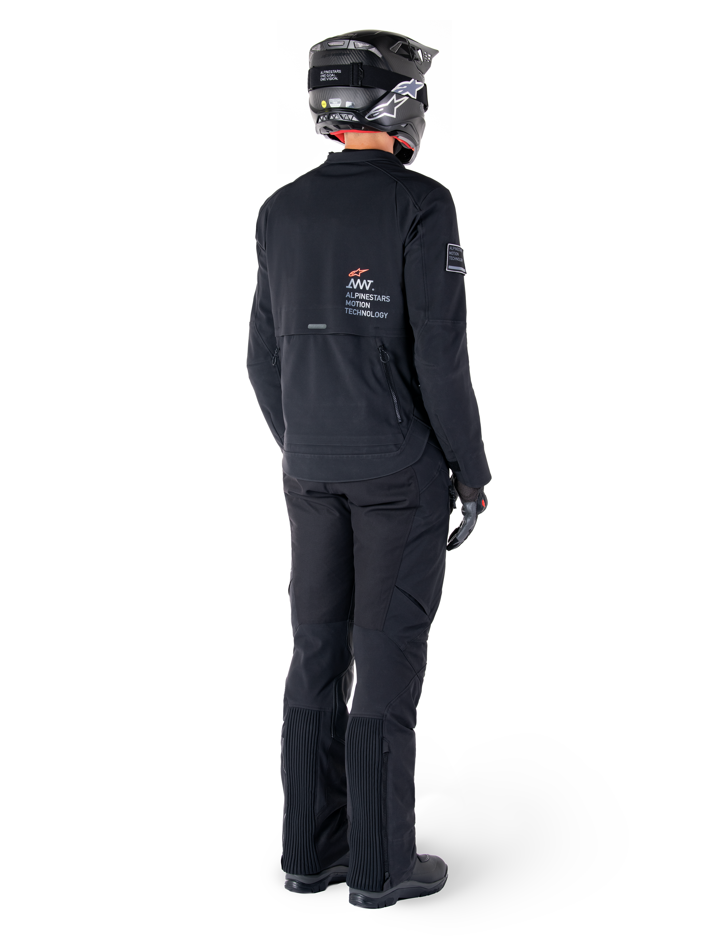 Alpinestars AMT-8 Stretch Drystar® XF jakke, sort, set bagfra af en kører iført jakken med matchende sorte bukser og en sort hjelm, med 'Alpinestars Motion Technology' branding på ryggen, teknisk strækmateriale til adventure-motorcykelkørsel