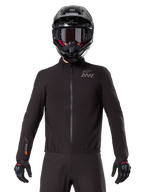 Alpinestars AMT-8 Stretch Drystar® XF Liner, sort vandtæt motorcykel-liner, med lynlås foran og elastik i taljen, AMT-logo på brystet og Drystar XF-logo på ærmet, her vist med sort hjelm og handsker.