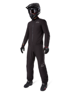 Alpinestars AMT-8 Stretch Drystar® XF-liner, sort vandtæt motorcykeldragt, båret med sort hjelm, goggles og handsker, med AMT- og Drystar XF-branding, funktionelt adventure-udstyr til beskyttelse i al slags vejr.
