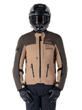 Alpinestars AMT-8 Stretch Drystar XF jakke, motorcykel adventure touring-jakke, mørk khaki og mørkebrun, med orange Astars-logo og sorte lynlåse, bæres med sort adventure-hjelm og handsker, komplet køreudstyr