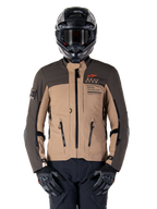 Alpinestars AMT-8 Stretch Drystar XF jakke, motorcykel adventure touring-jakke, mørk khaki og mørkebrun, med orange Astars-logo og sorte lynlåse, bæres med sort adventure-hjelm og handsker, komplet køreudstyr