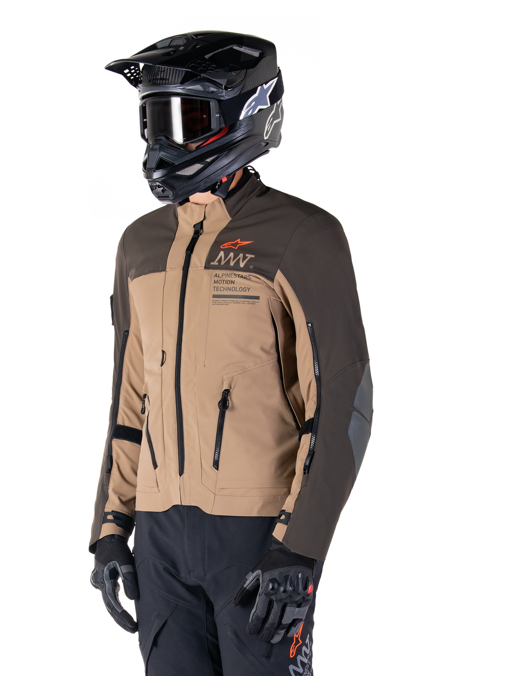 Alpinestars AMT-8 Stretch Drystar® XF Jakke, adventure motorcykeljakke, mørkebrun og mørk khaki, båret med en sort off-road hjelm og goggles, med Alpinestars Motion Technology-branding og lynlåslukkede ventilationsåbninger.