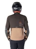 Alpinestars AMT-8 Stretch Drystar® XF jakke, set bagfra, mørkebrunt og mørkt khaki tofarvet design, med Alpinestars Motion Technology-branding, baglomme med lynlås og beskyttende albuepaneler, adventure touring motorcykelbeklædning