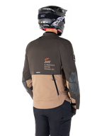 Alpinestars AMT-8 Stretch Drystar® XF jakke, adventure motorcykeljakke, mørkebrun og mørk khaki, set bagfra med AMT Alpinestars Motion Technology-branding, tofarvet tekstildesign med ventilationslynlåse bagpå og bagudstødning i skifertagdesign, båret med sort hjelm og kørebukser
