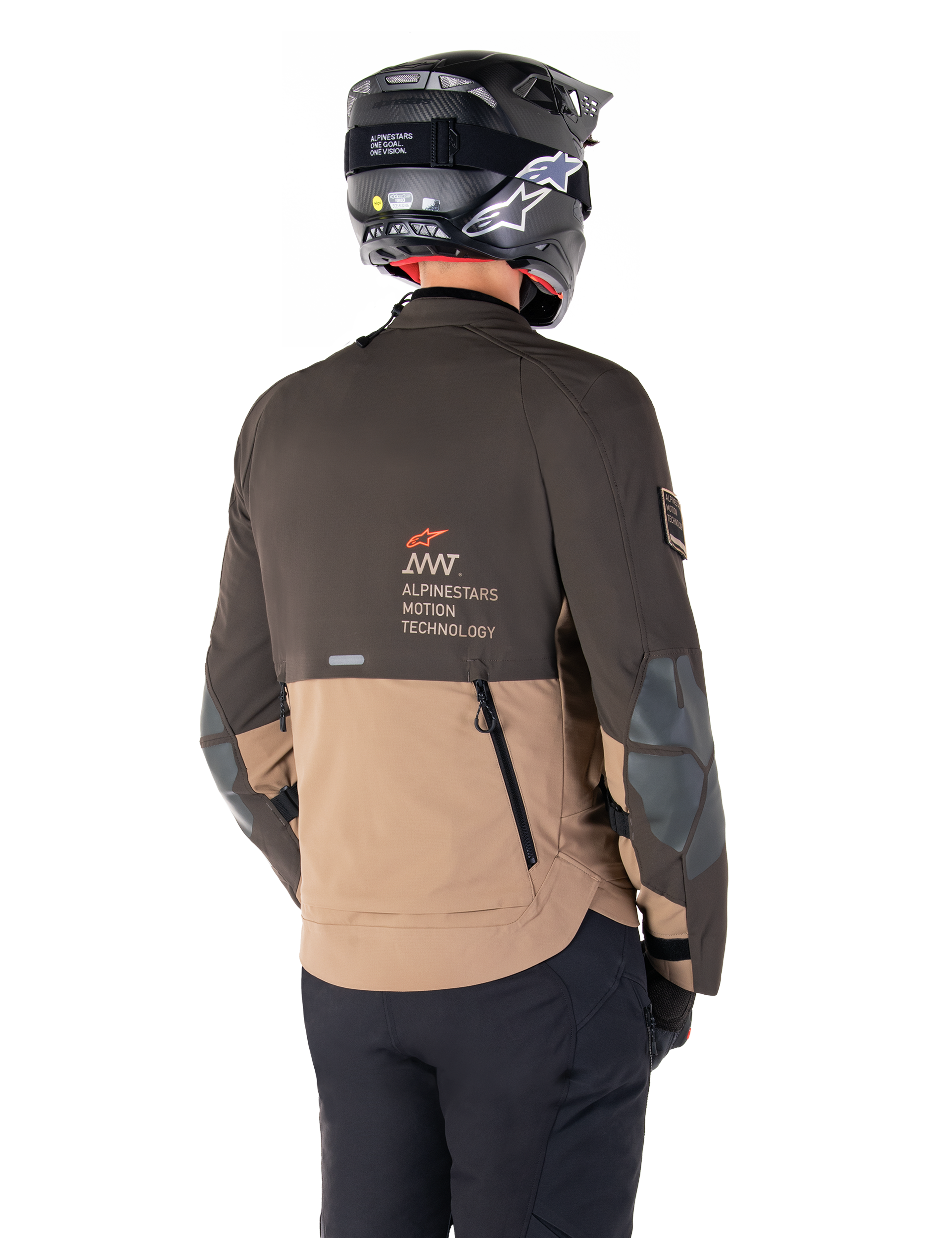 Alpinestars AMT-8 Stretch Drystar® XF jakke, adventure motorcykeljakke, mørkebrun og mørk khaki, set bagfra med AMT Alpinestars Motion Technology-branding, tofarvet tekstildesign med ventilationslynlåse bagpå og bagudstødning i skifertagdesign, båret med sort hjelm og kørebukser