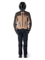 Alpinestars AMT-8 Stretch Drystar® XF jakke, adventure motorcykeljakke, mørkebrun og mørk khaki, båret med sort hjelm, motorcykelbriller, sorte handsker, sorte bukser og sorte støvler, med brystventilationsporte og AMT-branding, koordineret udstyr til adventure touring