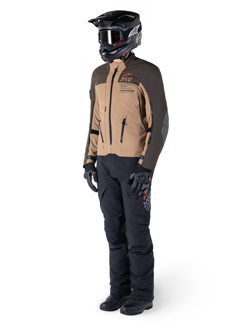 Adventure-rytter iført komplet udstyr, Alpinestars AMT-8 Stretch Drystar® XF-jakke i mørkebrun og mørk khaki, kombineret med sorte adventure-bukser, sort hjelm, handsker og støvler, med orange AMT-branding og tekniske ventilationslynlåse til langdistance-touring