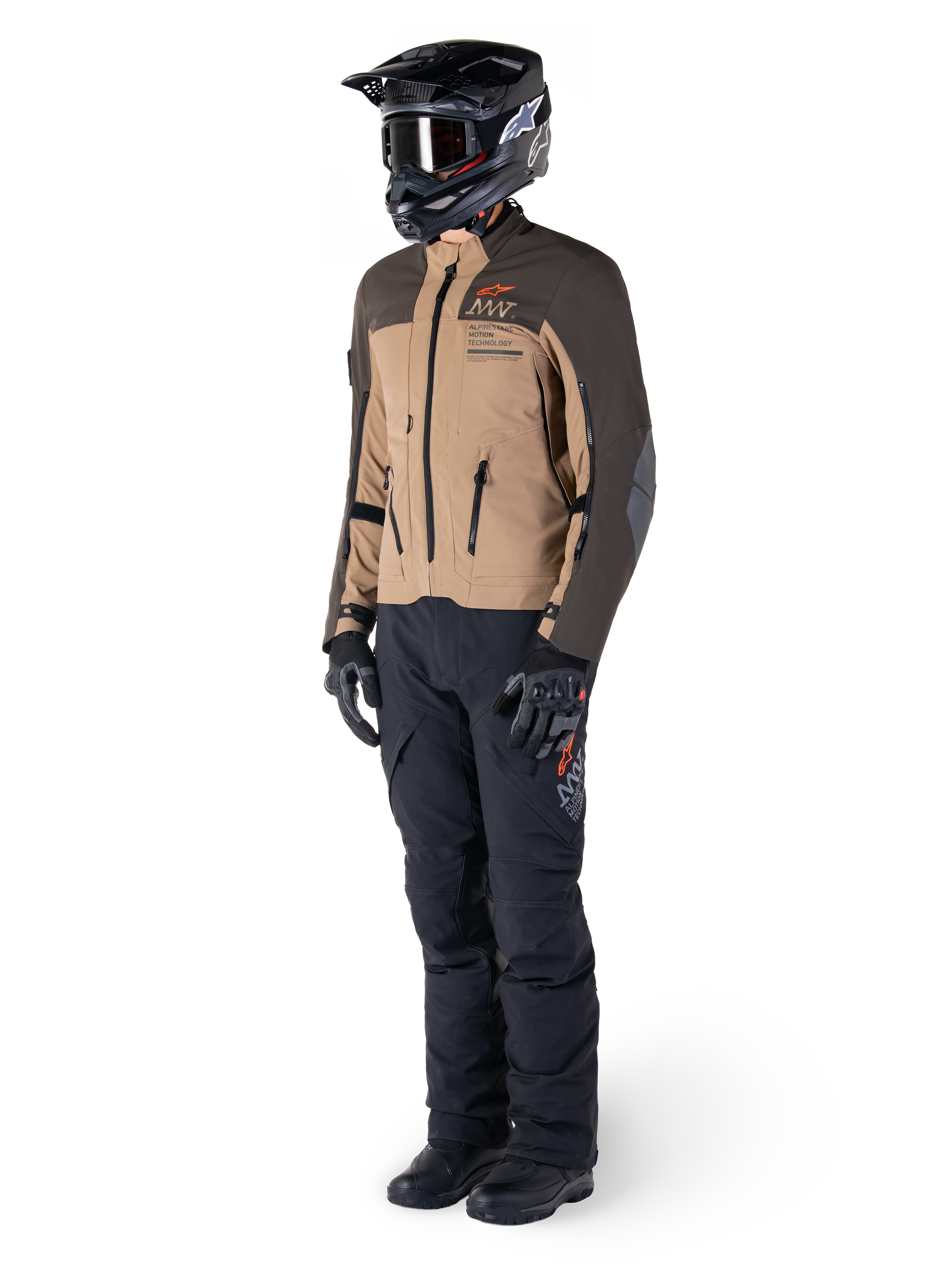 Adventure-rytter iført komplet udstyr, Alpinestars AMT-8 Stretch Drystar® XF-jakke i mørkebrun og mørk khaki, kombineret med sorte adventure-bukser, sort hjelm, handsker og støvler, med orange AMT-branding og tekniske ventilationslynlåse til langdistance-touring