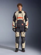 Alpinestars Halo Pro Drystar® XF lamineret jakke, Mastic Black, adventure-motorcykeljakke båret af en model med matchende bukser og handsker, sandfarvede og sorte tekstilpaneler med markante røde logoer, modulært design til kørsel i alt terræn