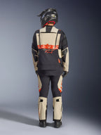 Alpinestars Halo Pro Drystar® XF lamineret jakke, adventure motorcykeljakke, Mastic Black, set bagfra af en kører med matchende bukser og sort hjelm, med markant orange Alpinestars-branding og modulære ventilationspaneler til alsidig eventyrkørsel