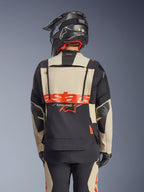 Alpinestars Halo Pro Drystar® XF lamineret jakke i Mastic Black, set bagfra, som viser modulært rygpanel med rødt logo og ventilationslynlåse, båret af en kører med matchende adventure-bukser og en sort hjelm