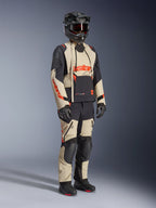Alpinestars Halo Pro Drystar® XF lamineret jakke i Mastic Black, adventure-motorcykeljakke båret med matchende bukser, full-face hjelm, handsker og støvler, sandfarvede og sorte paneler med røde logoer, teknisk design til alle sæsoner