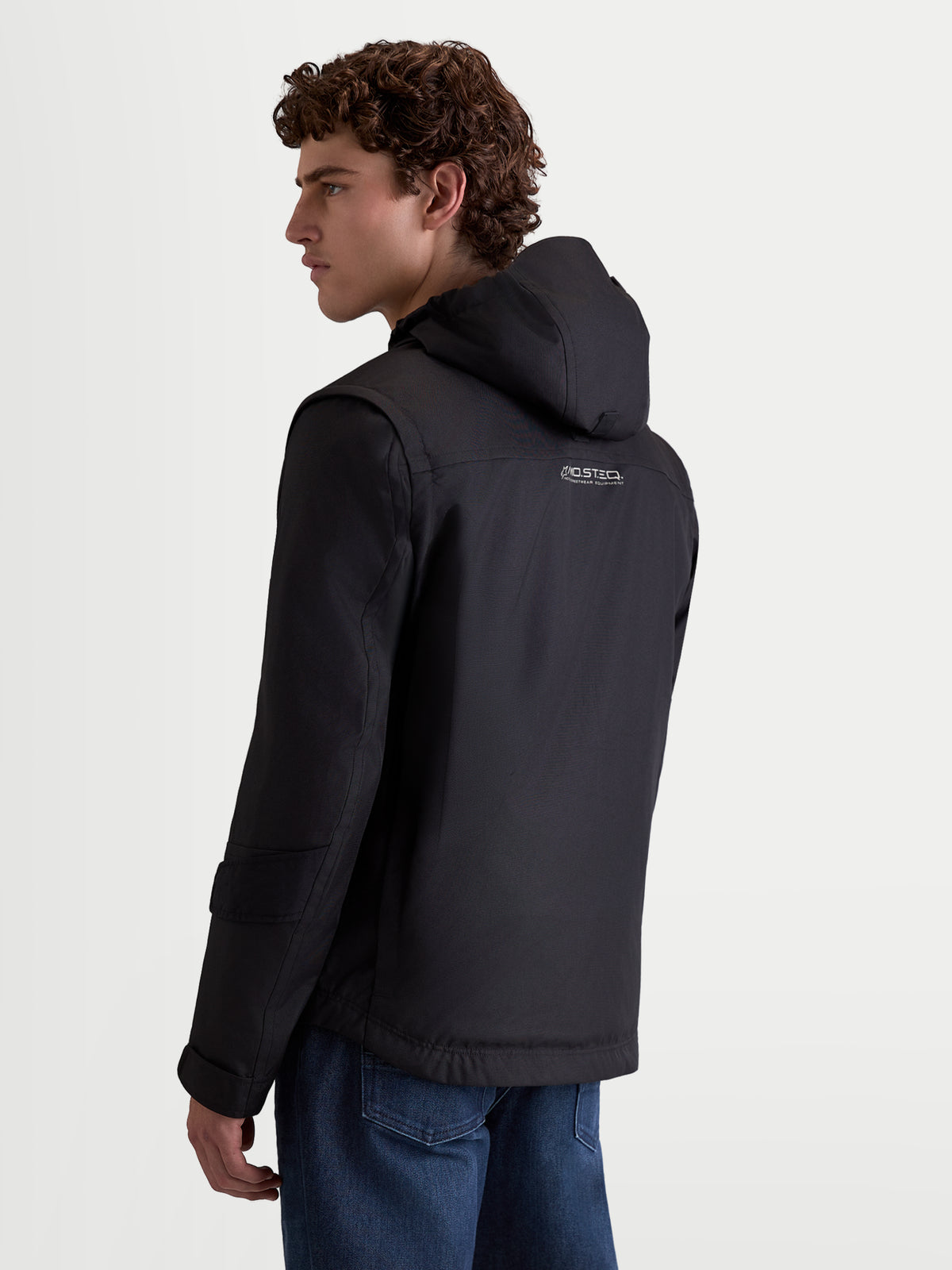 Alpinestars Morfex Parka WP Jkt, herre-motorcykelparkajakke i sort, set bagfra på mandlig model iført tekstiljakke med integreret hætte