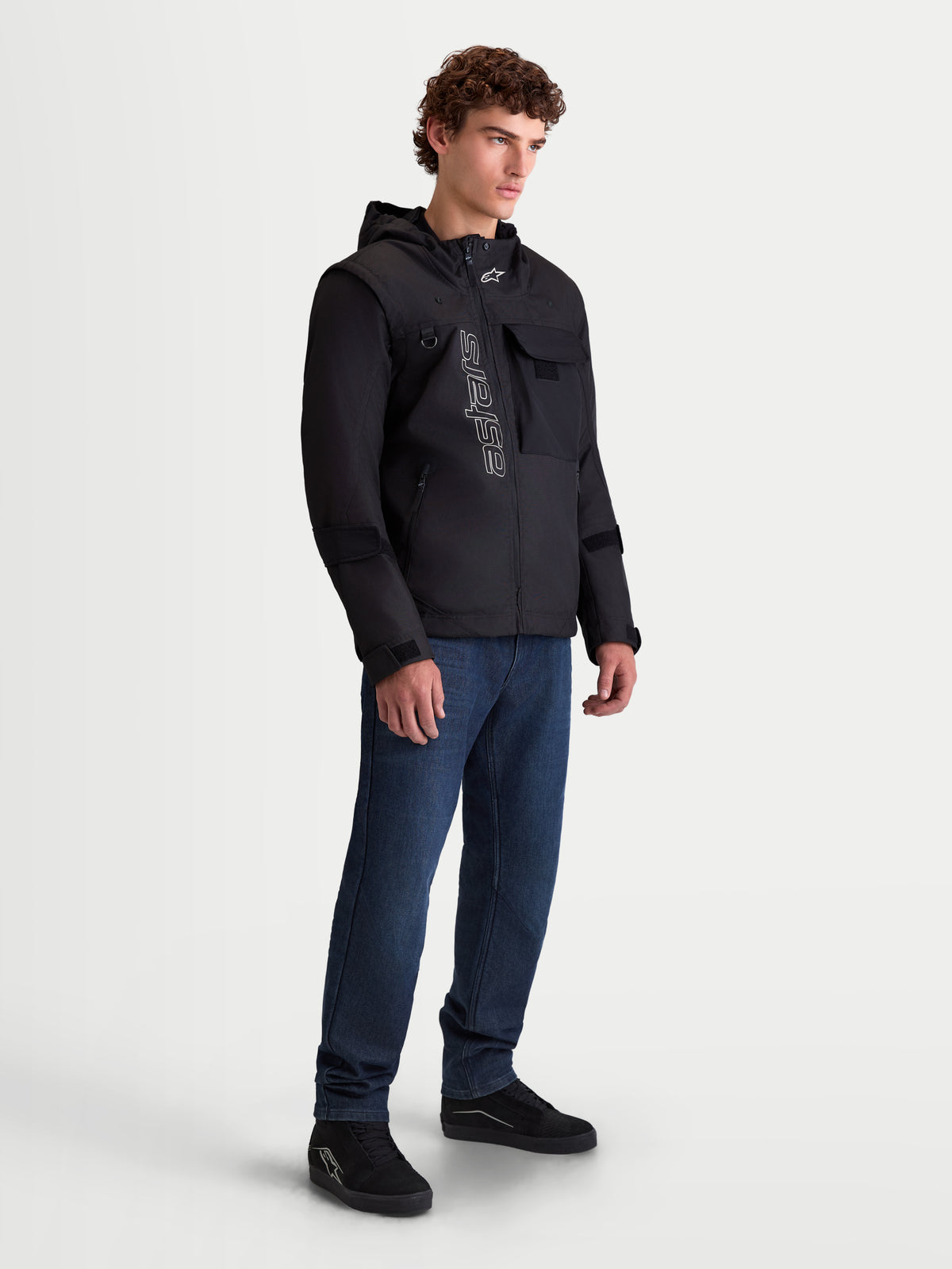 Alpinestars Morfex Parka WP-jakke, herre-urban-motorcykeljakke i sort, trekvart-vinkel på model iført den modulære jakke med integreret hætte og streetwear-stil