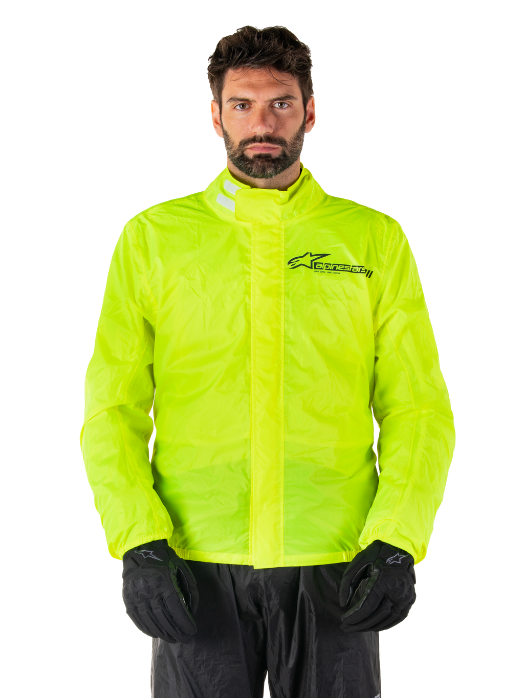 Alpinestars Hurricane Rain V2-jakke, motorcykelregnjakke, neongul, båret af model med sorte bukser og handsker, høj krave med reflekterende detaljer, front-stormklap med Alpinestars-logo, vandtæt udstyr med høj synlighed