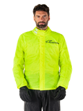 Alpinestars Hurricane Rain V2-jakke, motorcykelregnjakke, neongul, båret af model med sorte bukser og handsker, høj krave med reflekterende detaljer, front-stormklap med Alpinestars-logo, vandtæt udstyr med høj synlighed