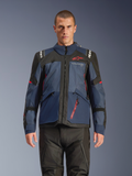 Alpinestars Andes V4 Drystar® jakke, adventure-motorcykeljakke, Night Navy og Mood Indigo med sorte paneler, båret af model med sorte kørebukser, rødt Alpinestars-logo på brystet og rød lynlåsdetalje, holdbar tekstilkonstruktion til touring i al slags vejr.
