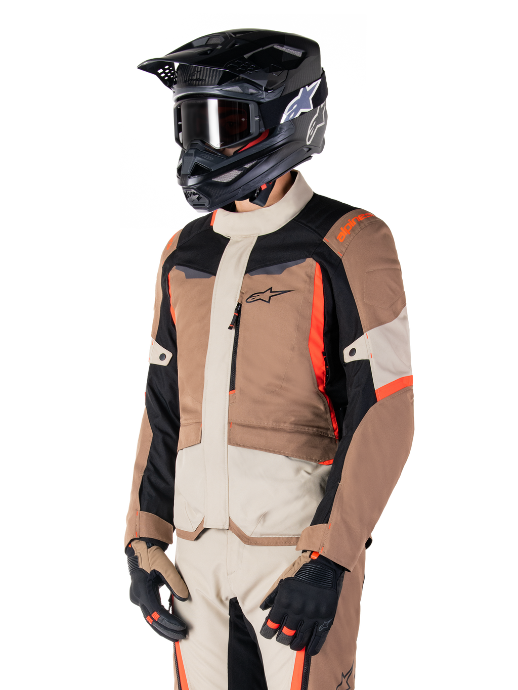 Alpinestars ST-1 vandtæt jakke, adventure touring-jakke, mørk khaki, sand, sort og rød fluo, bæres af en kører med en sort motocrosshjelm og briller, design med flere paneler, cargo-lommer og Alpinestars-branding på brystet