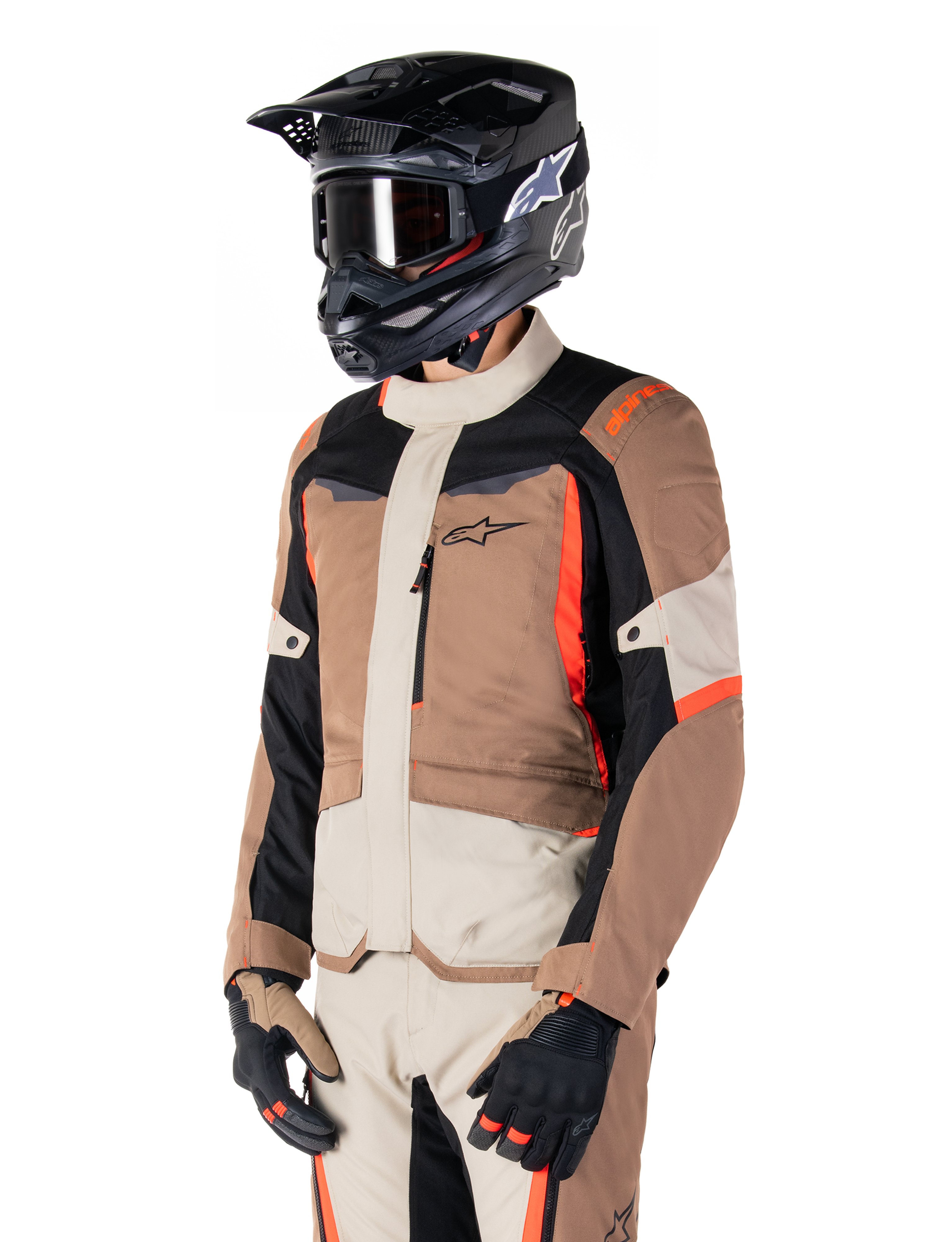 Alpinestars ST-1 vandtæt jakke, adventure touring-jakke, mørk khaki, sand, sort og rød fluo, bæres af en kører med en sort motocrosshjelm og briller, design med flere paneler, cargo-lommer og Alpinestars-branding på brystet