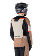 Alpinestars ST-1 vandtæt jakke, adventure touring-jakke, Dark Khaki Sand Black Red Fluo, set bagfra med farveopdelte tekstilpaneler, fluorescerende røde detaljer og Alpinestars-branding nederst på ryggen, båret af en kører med sort hjelm
