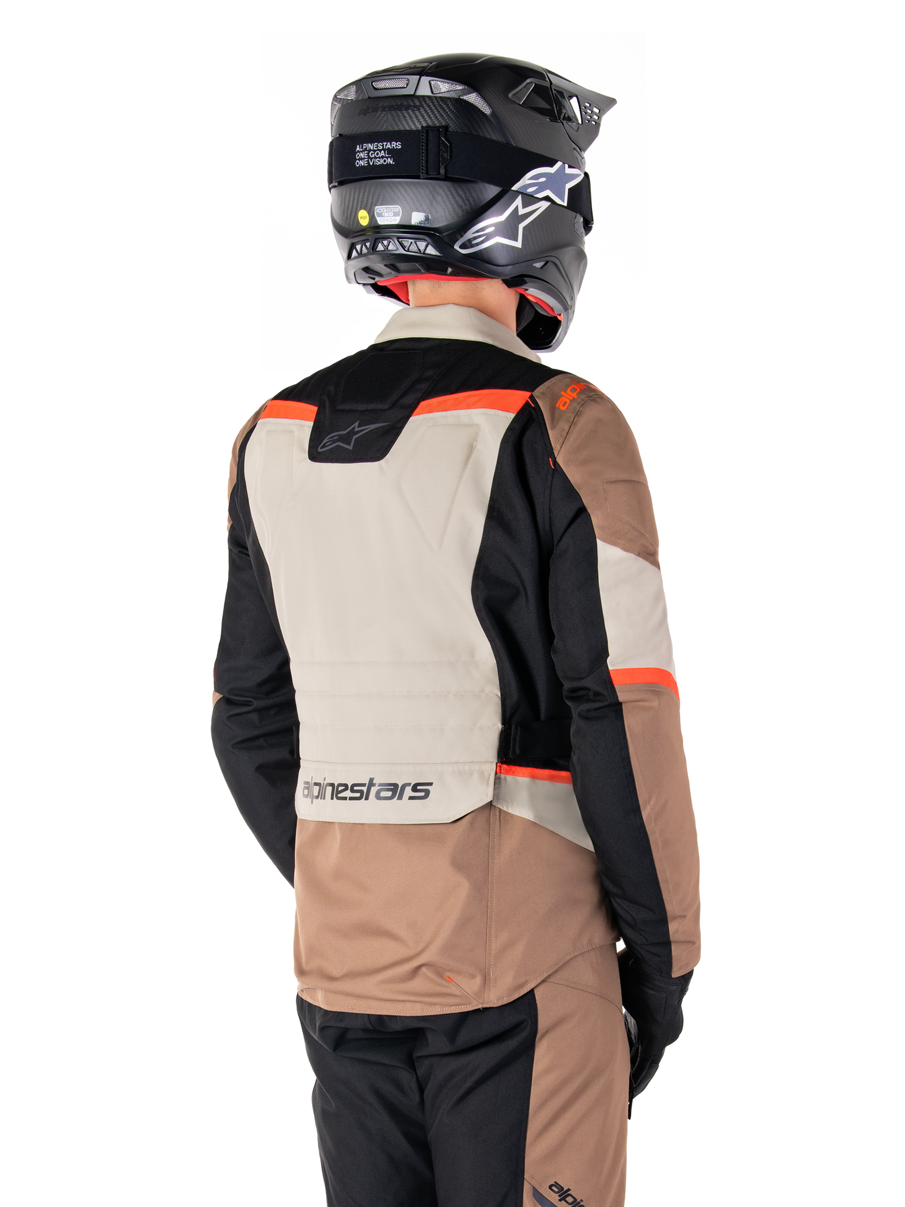 Alpinestars ST-1 vandtæt jakke, adventure touring-jakke, Dark Khaki Sand Black Red Fluo, set bagfra med farveopdelte tekstilpaneler, fluorescerende røde detaljer og Alpinestars-branding nederst på ryggen, båret af en kører med sort hjelm