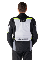 Alpinestars ST-1 Waterproof Jacket, Adventure Touring Jacket, Ice Gray Black and Yellow Fluo, back view on a model, featuring a light gray rear panel with Alpinestars logos, neon yellow accents, and streamlined protective design