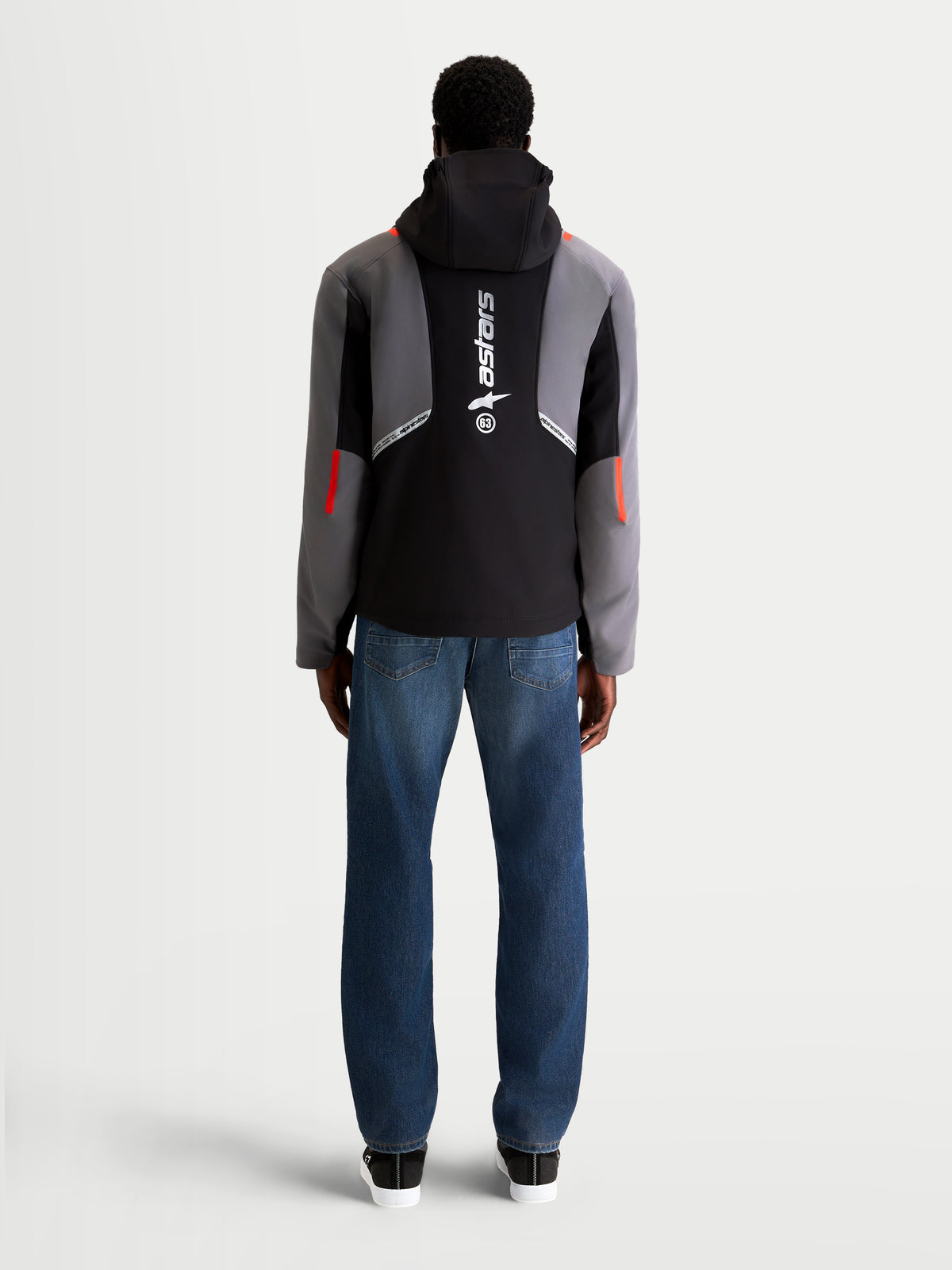 Alpinestars C 5 Drystar jakke, herre-motorcykeljakke i sort og mørkegrå, set bagfra på model iført jeans, med integreret hætte og stort vertikalt logo på ryggen