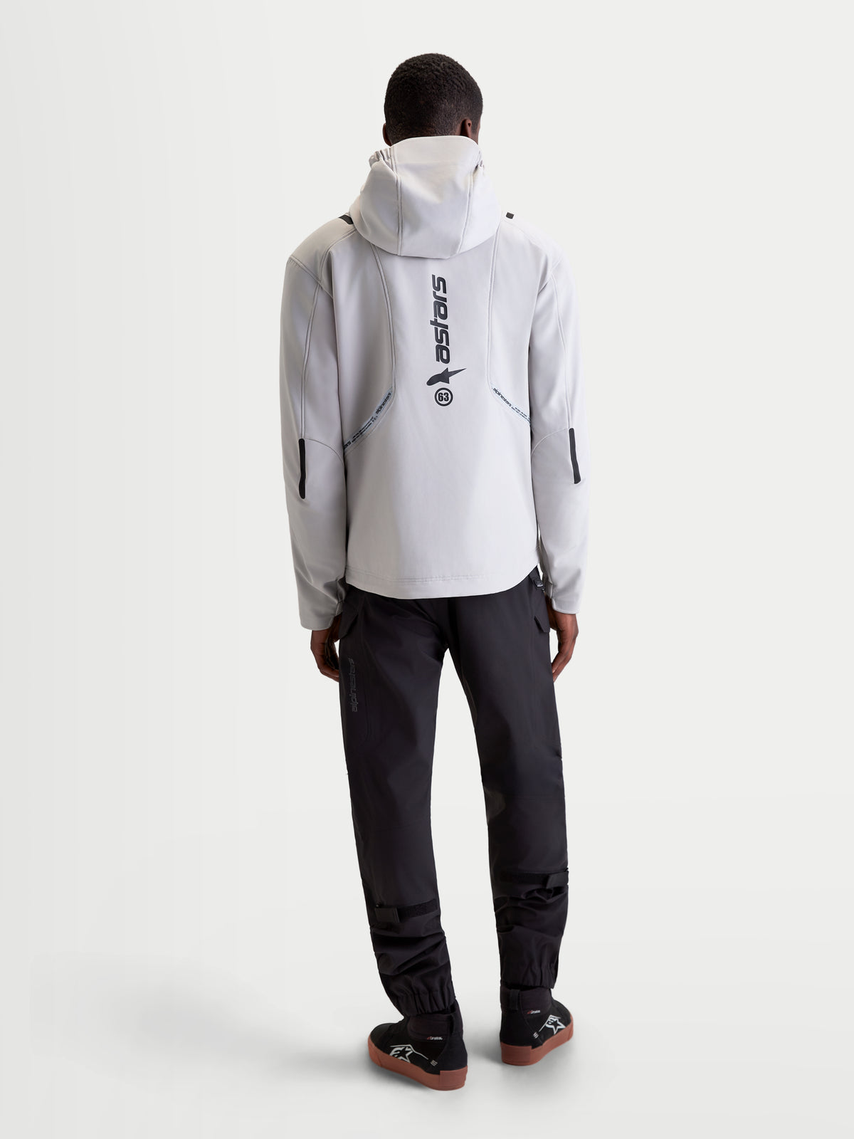 Alpinestars C 5 Drystar Jakke, herre-urban-motorcykeltekstiljakke i lys grå og sort, set bagfra med integreret hætte og reflekterende branding båret af en model