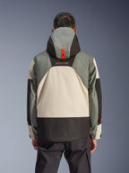 Alpinestars Mospher vandtæt jakke set bagfra i Fur Gray Black Ice, med et design af grå, creme og sorte paneler i flere toner, parka-silhuet med hætte med rød trykknap til forankring, 'MO.ST.EQ.'-branding, kombineret med sorte cargo-kørebukser