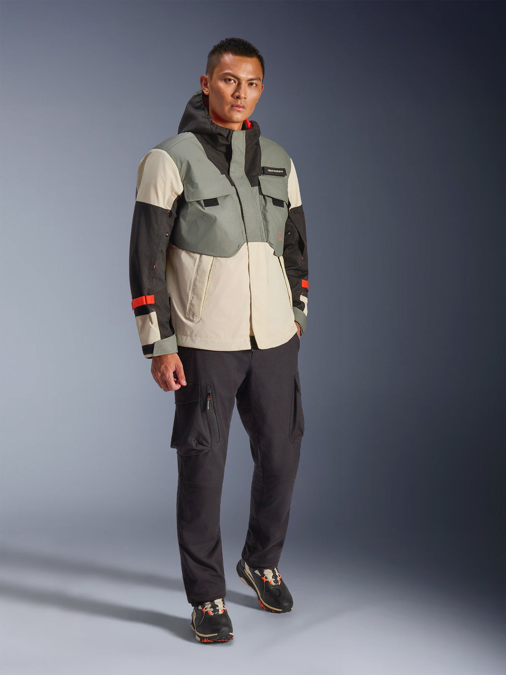Alpinestars Mospher vandtæt jakke i Fur Gray Black Ice, flerfarvet teknisk motorcykel-parka med grå, sorte og råhvide paneler og røde accenter, funktionelt design med store lommer og hætte, båret med mørkegrå cargobukser og sorte sneakers, urbant moderne motorcykeludstyr
