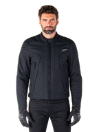 Alpinestars Clayton WR jakke, sort motorcykeljakke båret af model, med quiltede skulderdetaljer og teknisk grafik, central Vislon-lynlås, vertikale lynlåslommer, lille hvidt logo på brystet, urbant køreudstyr til brug på vej