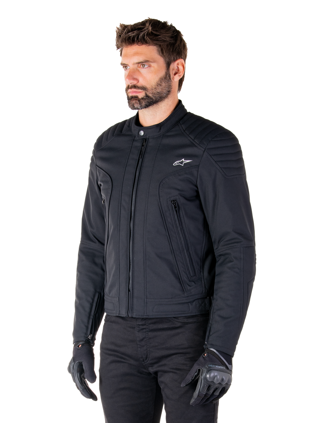 Alpinestars Clayton WR Jakke, sort, urban motorcykeljakke i tekstil med quiltede detaljer på skuldre og underarme, slim-fit design, mat finish, båret af en kører med sorte handsker.