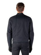 Alpinestars Clayton WR Jakke, sort, set bagfra på en mand iført den vandafvisende urbane motorcykeljakke, med quiltede forstærkninger på skuldre og albuer, ergonomiske linjer og en mat finish